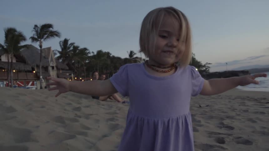 A young girl walking on a sandy beach