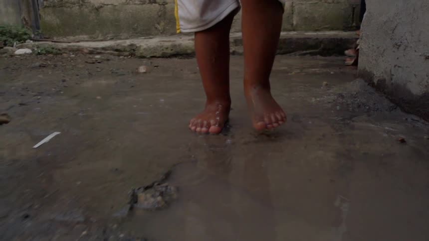 Person splashing their feet in puddles on the ground
