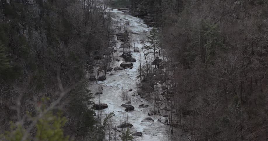 The water crashes against the rocks in the stream