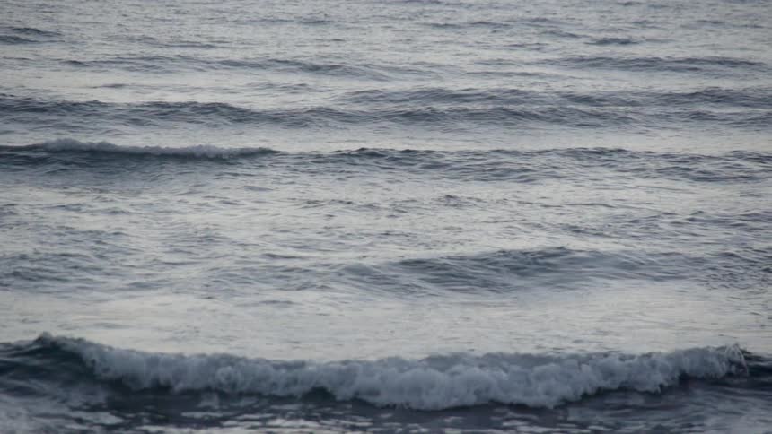 Slow motion shot of waves crashing towards shore