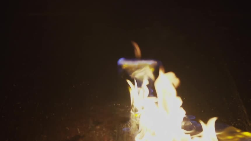 A flame slowly spreads across a surface