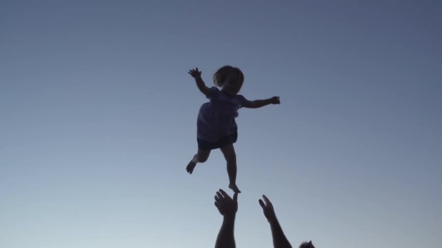 Man throwing his child up in the air