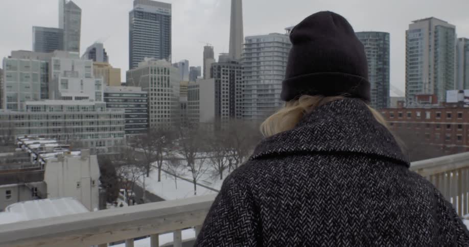 Woman walking over to a railing overseeing a city