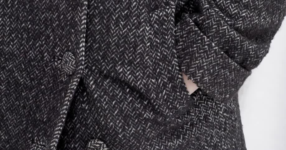 Person standing with their hands in their coat pocket