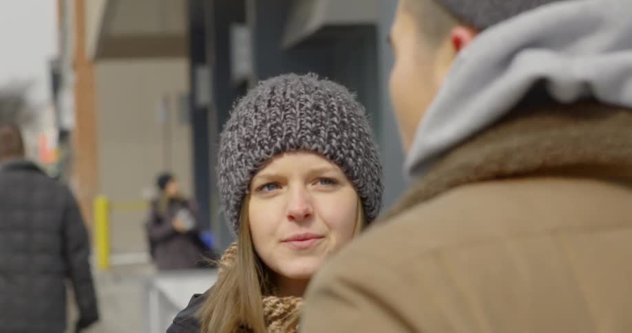 Woman looks to a man standing in front of her on a sunny day