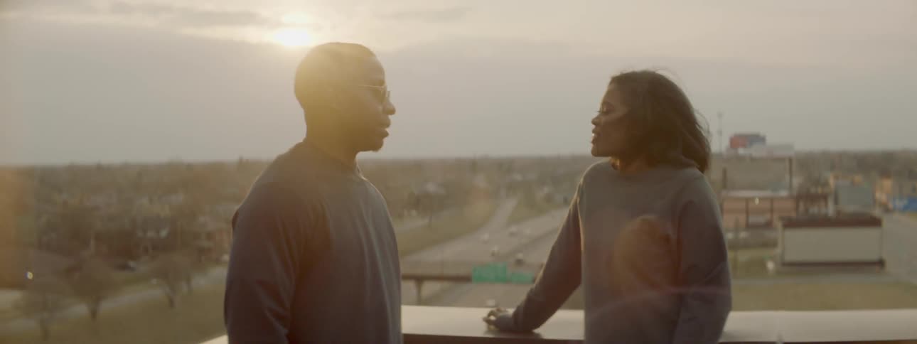 Man and woman talk in a city at sunset