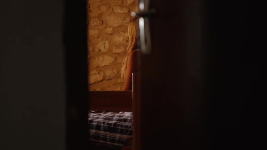 Woman sits on the edge of a bed