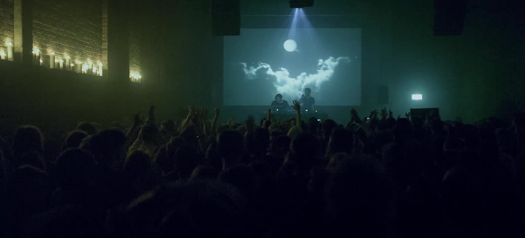 An audience cheers for a band on stage