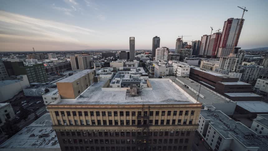 Rooftops and buildings in a city skyline as it moves from night to day