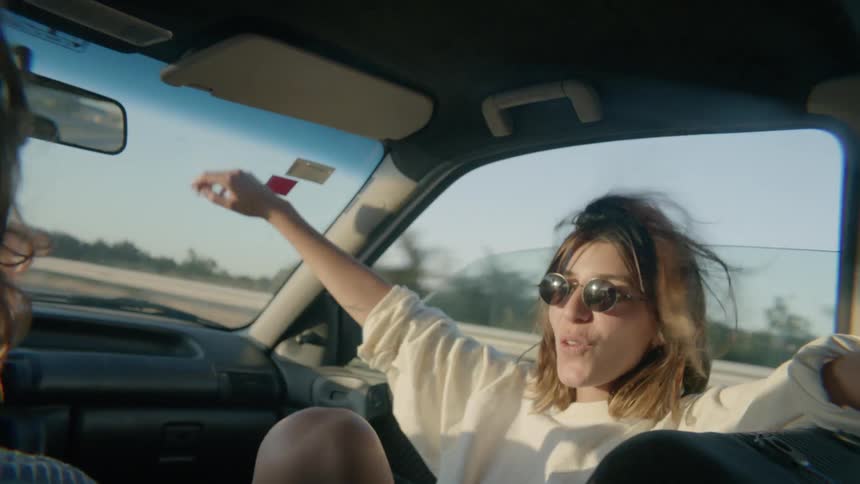 The woman puts on sunglasses in the car