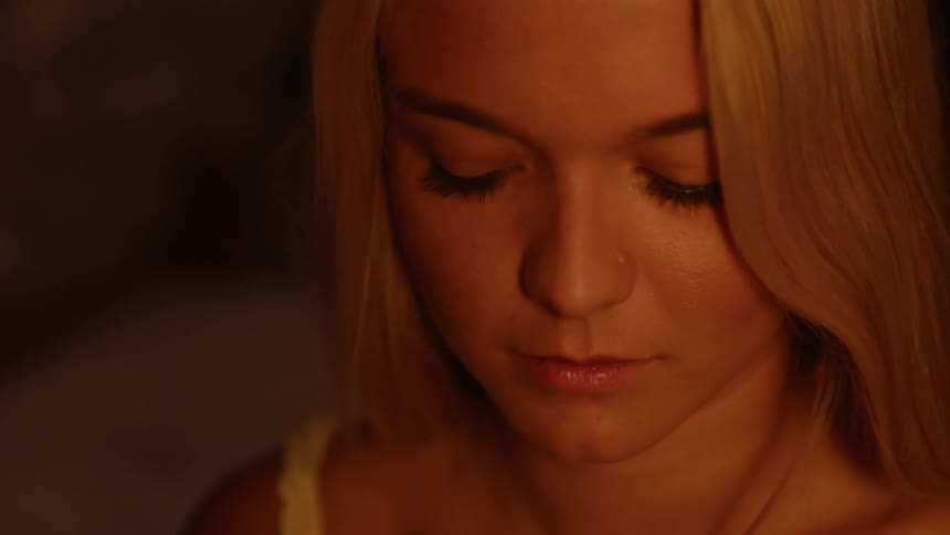 A woman begins to cry in the dark room