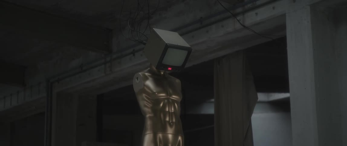 Monitor attached to a human statue in a dim room