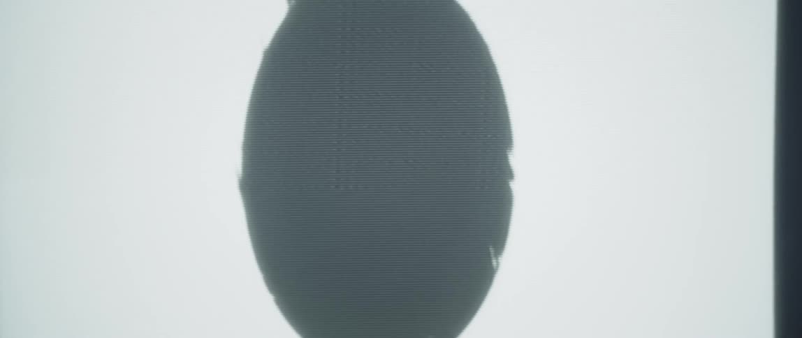 Shadow on an oval shaped object reflected in a window