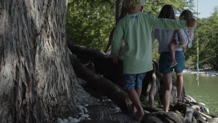 Woman and children walking along a stream