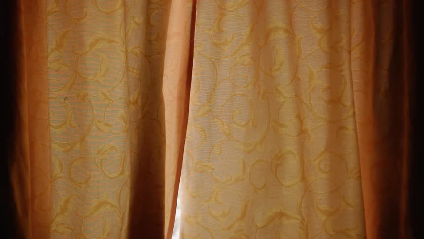 Orange curtains flutter lightly in the breeze