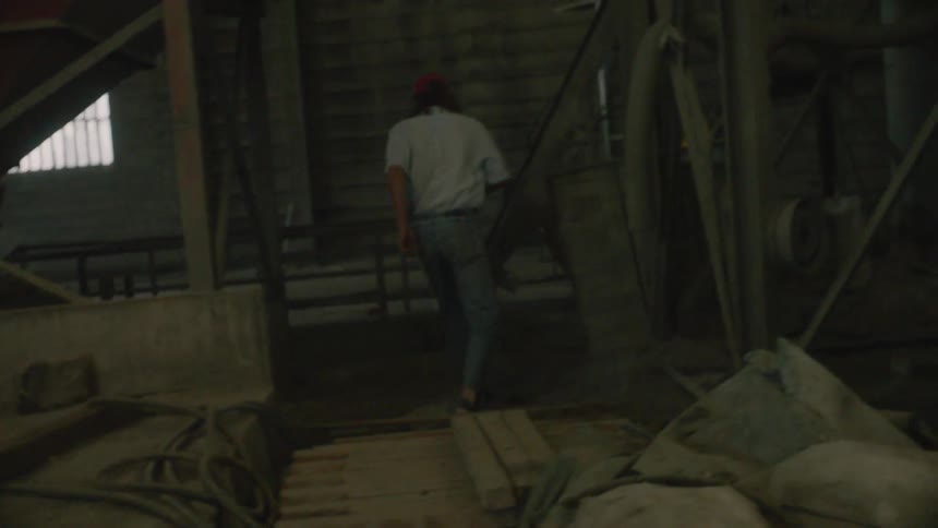 A man jumps over some pallets as he walks around a construction area
