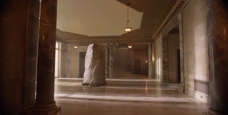 A large stone sits in an empty foyer