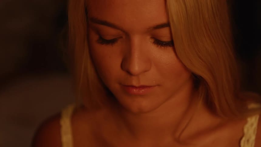 The woman begins to cry in the dark room