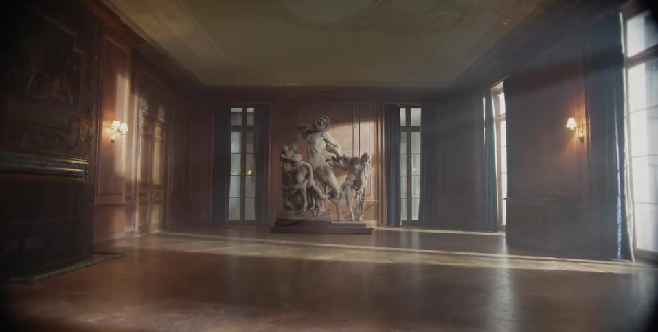 Sun shines in an empty room with a large statue on the other side