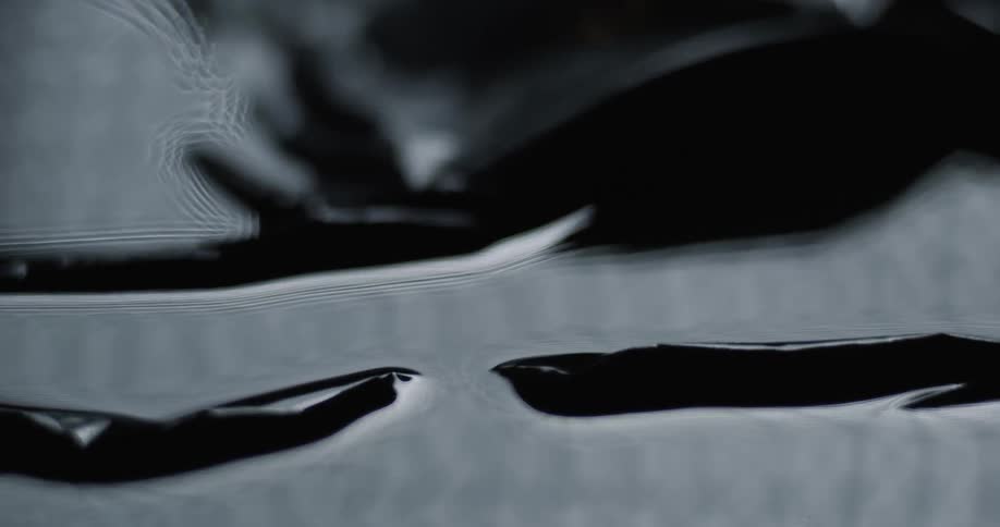 Light shines off dark ripply liquid