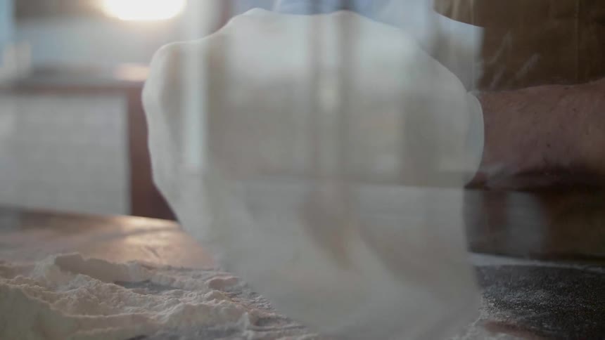 The person is shaping pizza dough