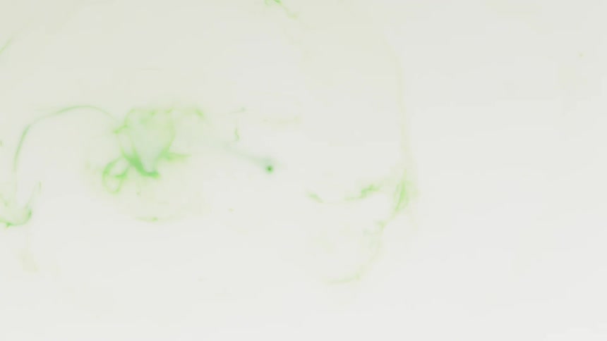 Green droplets fall into white liquid