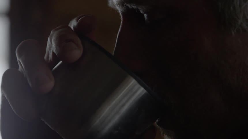 Man drinks from a steaming thermos