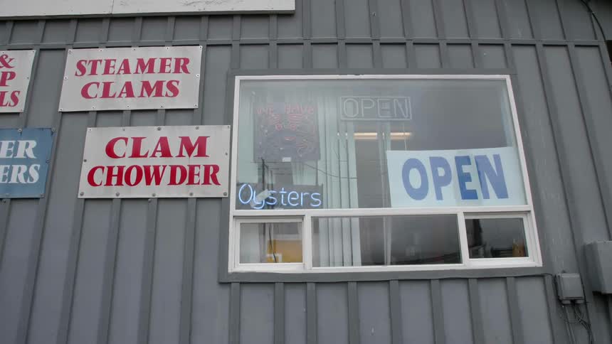Signs light up a seafood restaurant storefront