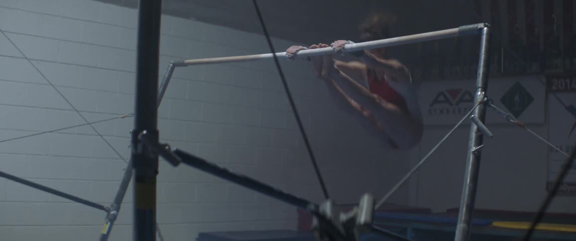 A woman is spinning on the gymnastics bars