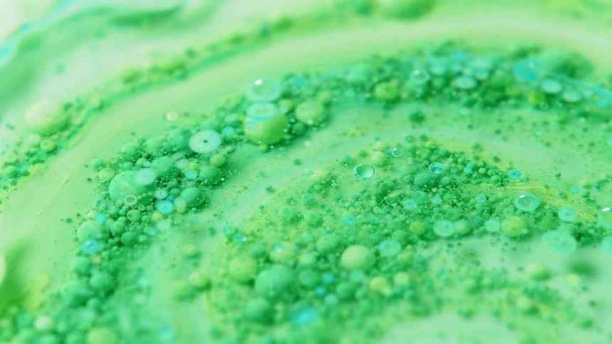 Green powder is being mixed into a thick liquid