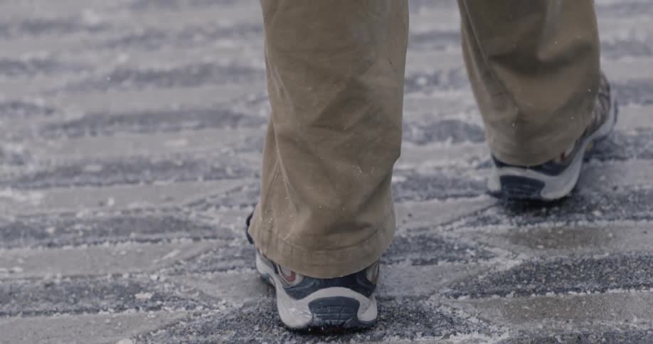 Person walking on a street with light snow falling