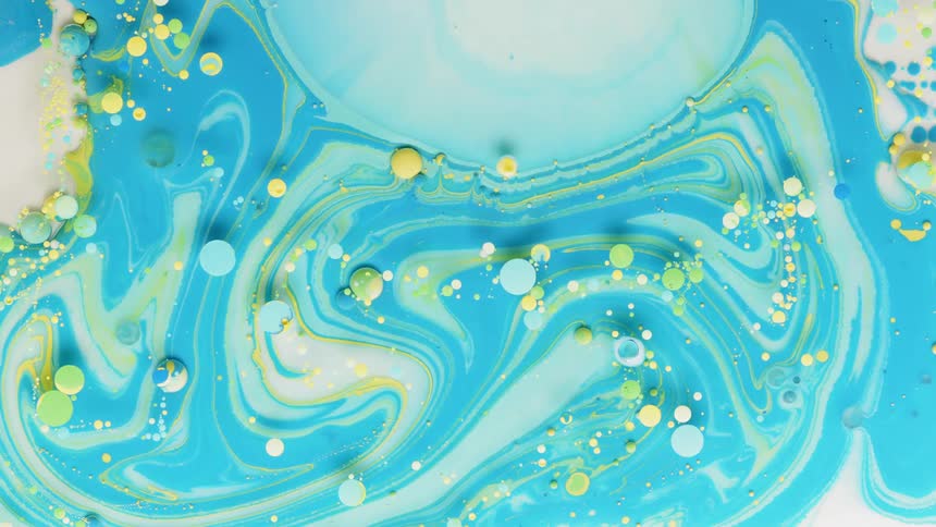Swirls and droplets of dye are moving in a liquid solution in abstract
