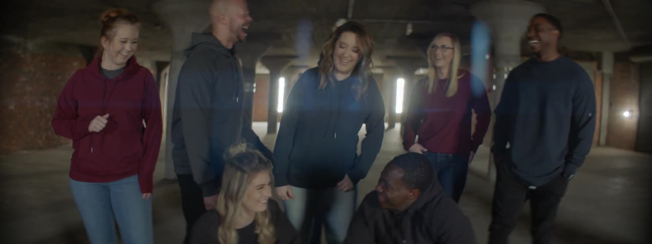 A group of people pose and then break out laughing
