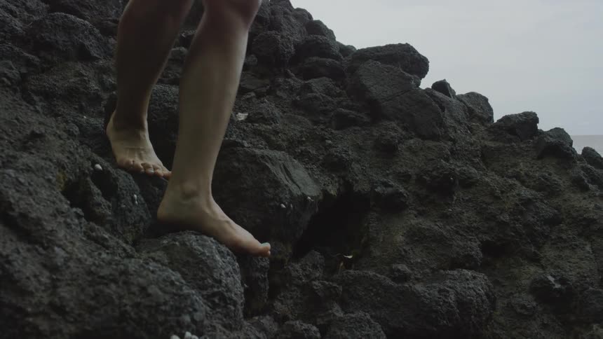 Woman stepping down on rocks and a log