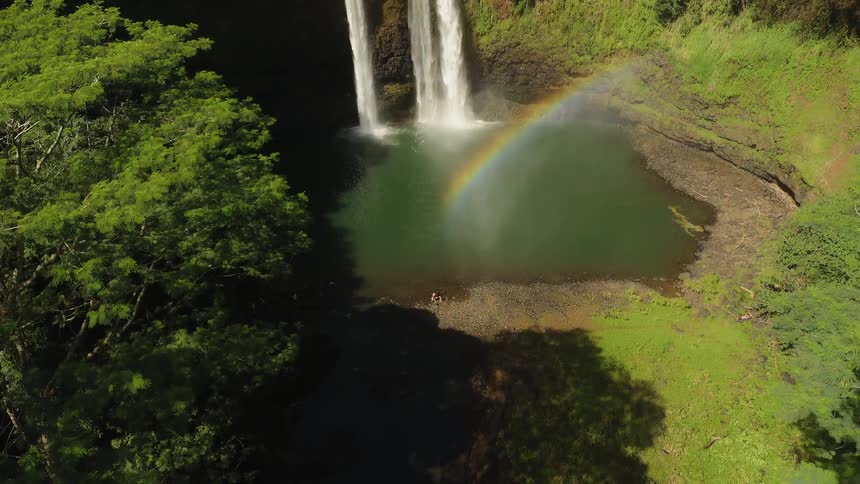 Water falls off the side of the stone cliff