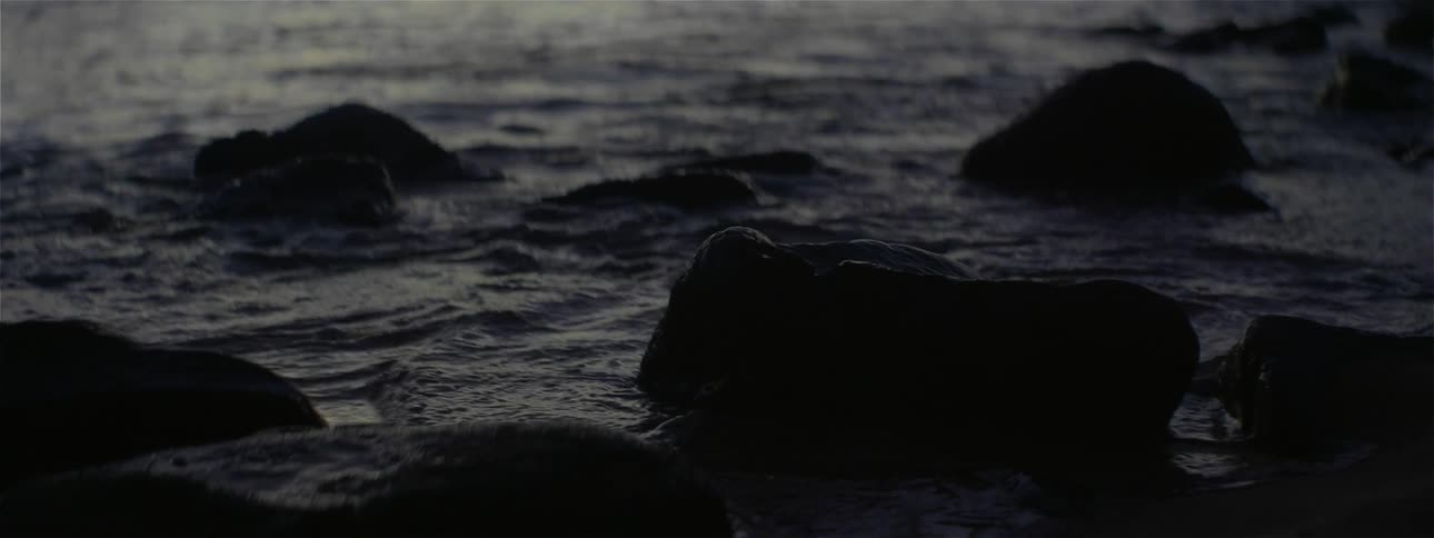 Ocean waves flow around and over rocks on shore
