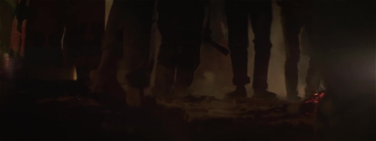 People dance and stamp their feet outside kicking up dirt and dust