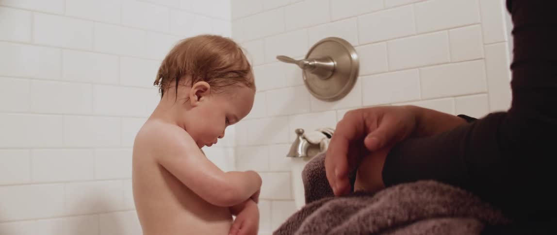 Child sitting in a bathtub rubs his arms