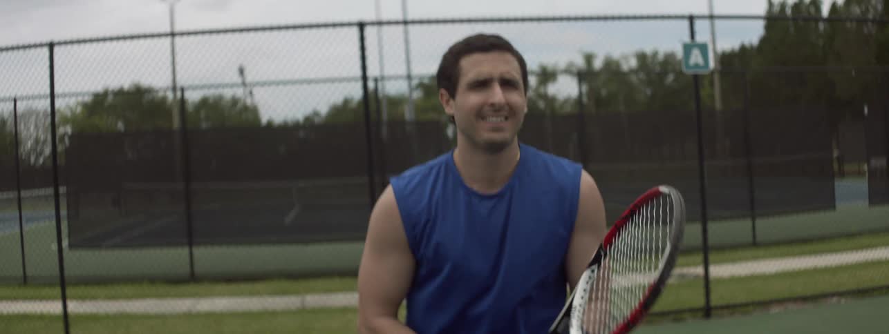 A man is hitting the tennis ball on the court