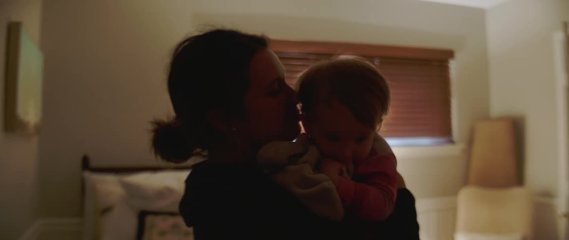 A woman holds and kisses a baby