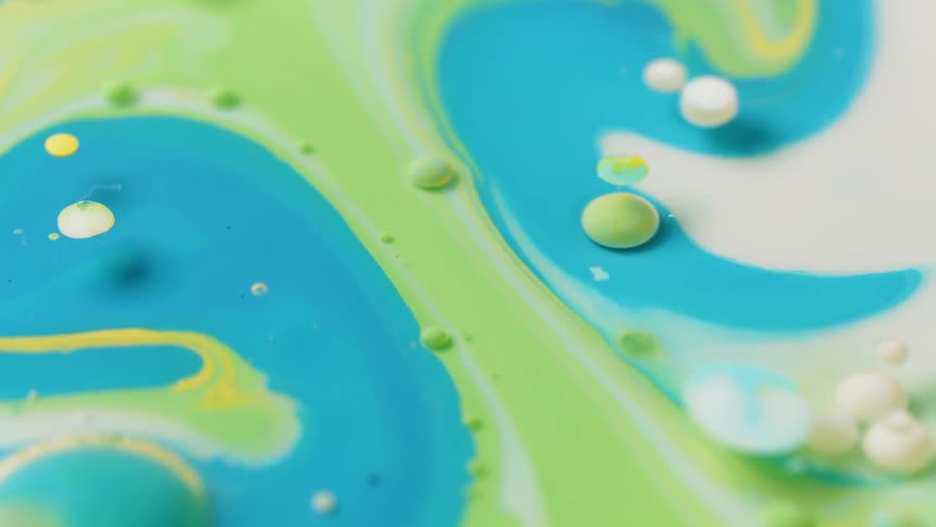 Green and blue liquid swirl together