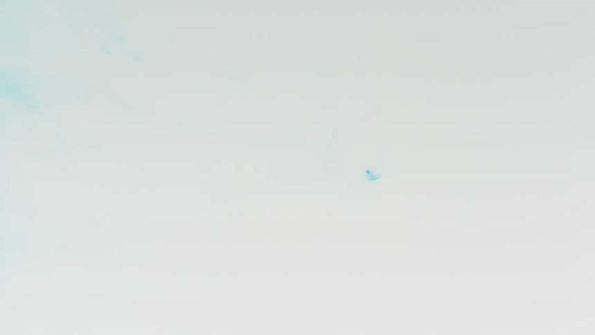 Blue droplet falls into a pool of white liquid
