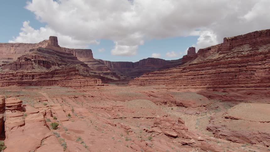 Clouds are casting shadows on cliffs in a canyon during the day