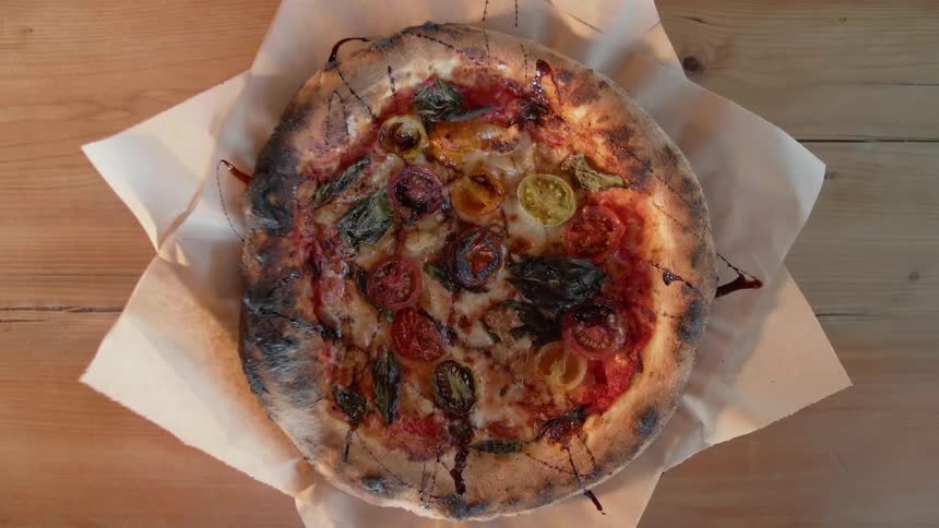 Pizza is placed on a wooden table
