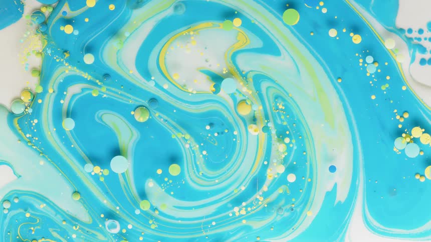 Yellow and blue dyes are swirling in a mixture in abstract