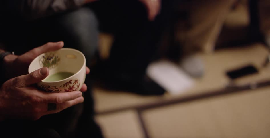Cup of green liquid being held by two hands