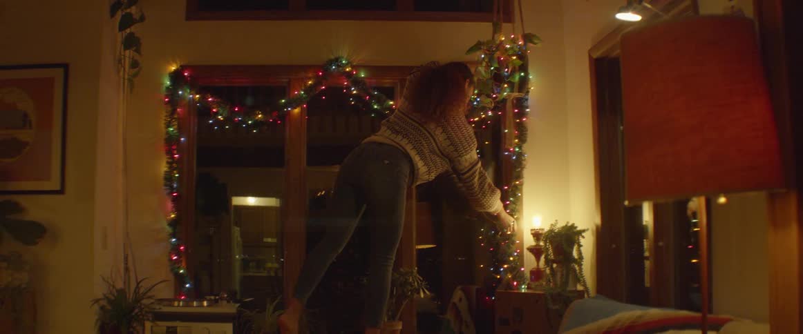 Woman hangs colored lights around the window