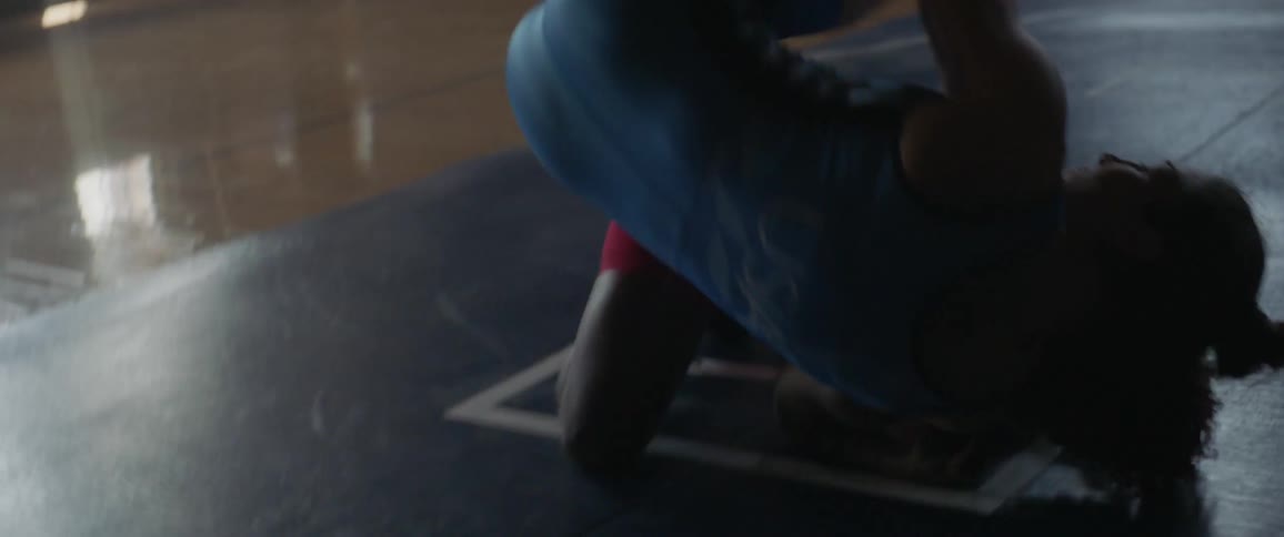 Two women wrestle in a gymnasium
