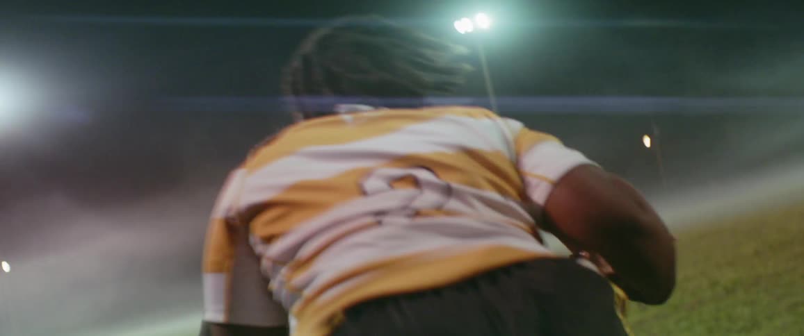 The two players wrestle on the field at night