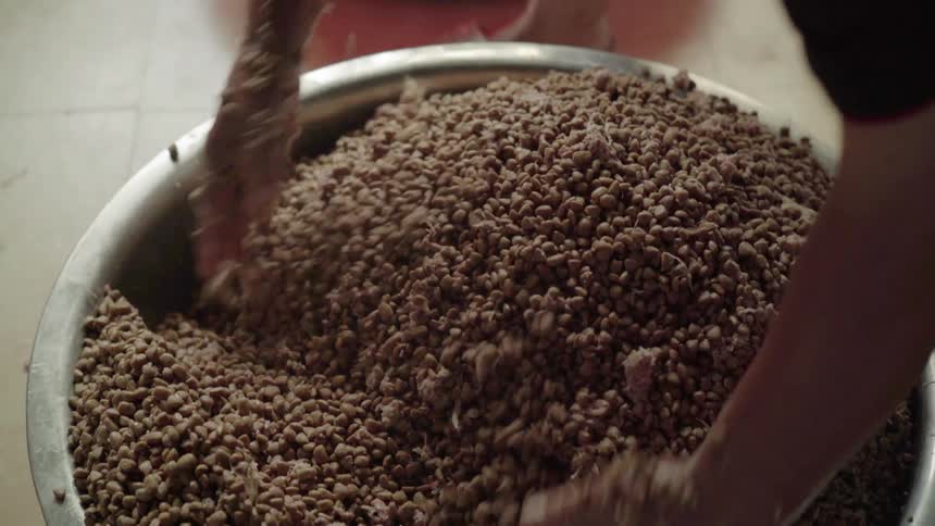 Man mixes a big bowl of food with his hands